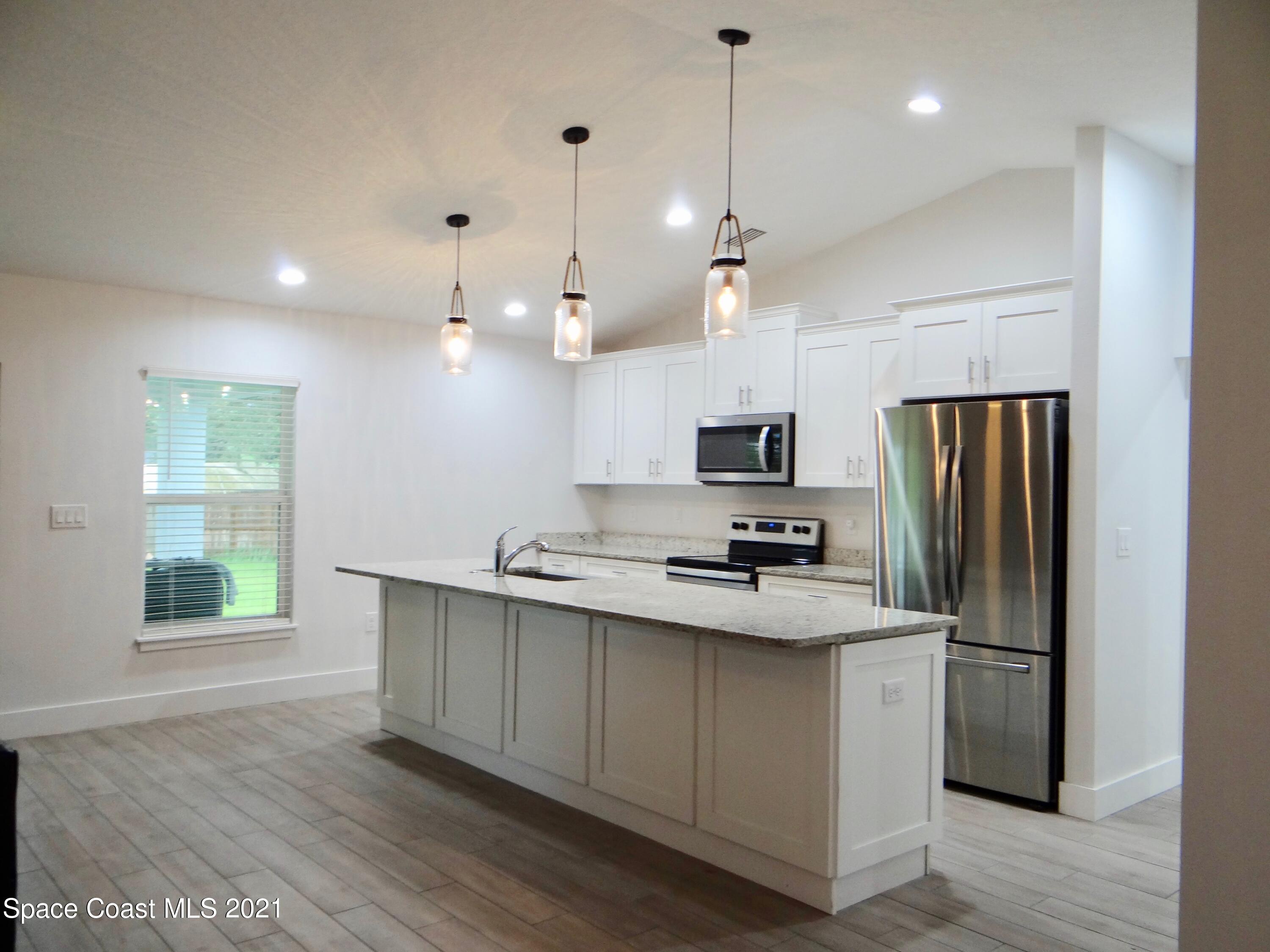 2725 Digby Road Southeast Palm Bay, FL 32909 - Photo 10 of 33 a kitchen with stainless steel appliances a refrigerator a sink appliances and a window