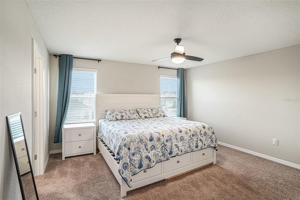 12940 Hawkstone Trail Boulevard Lithia, FL 33547 - Photo 12 of 33 a bedroom with a bed and a chandelier