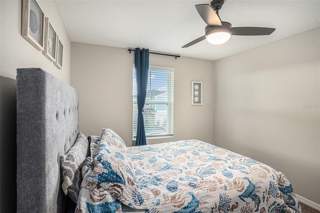 12940 Hawkstone Trail Boulevard Lithia, FL 33547 - Photo 18 of 33 a bedroom with a bed and a chandelier