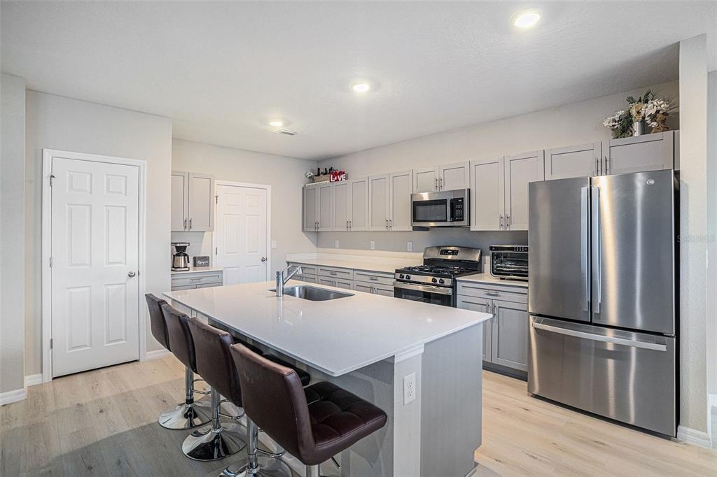 12940 Hawkstone Trail Boulevard Lithia, FL 33547 - Photo 2 of 33 a kitchen with stainless steel appliances a refrigerator stove microwave and cabinets