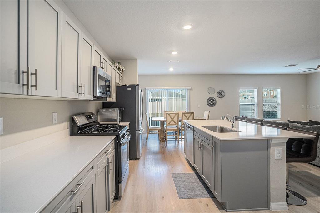 12940 Hawkstone Trail Boulevard Lithia, FL 33547 - Photo 3 of 33 a kitchen with stainless steel appliances granite countertop a sink stove and refrigerator
