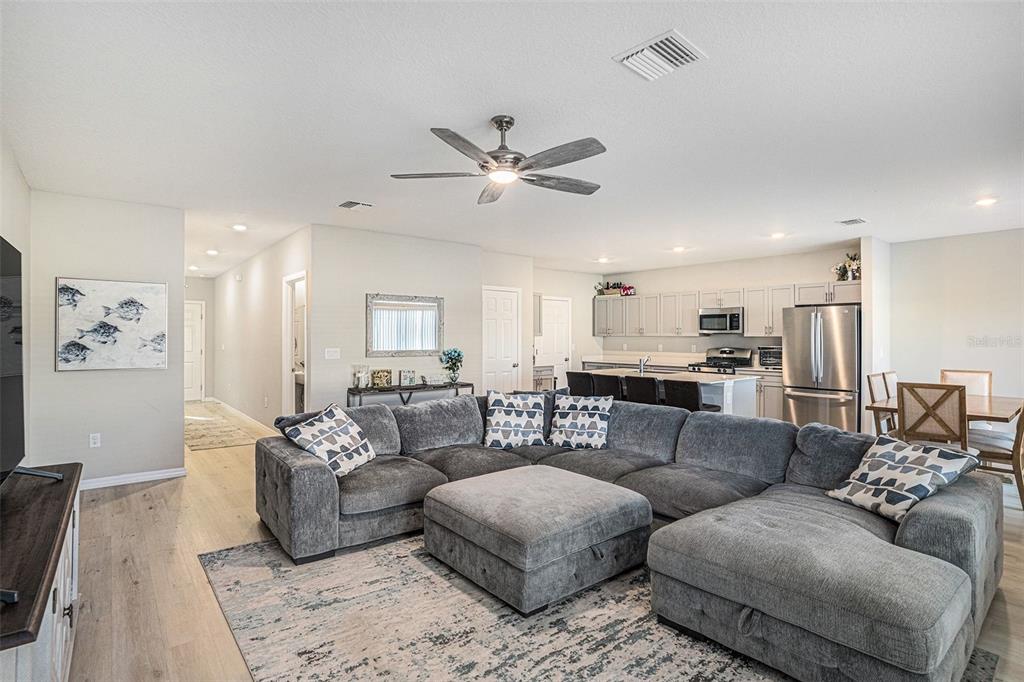 12940 Hawkstone Trail Boulevard Lithia, FL 33547 - Photo 4 of 33 a living room with furniture kitchen view and a chandelier