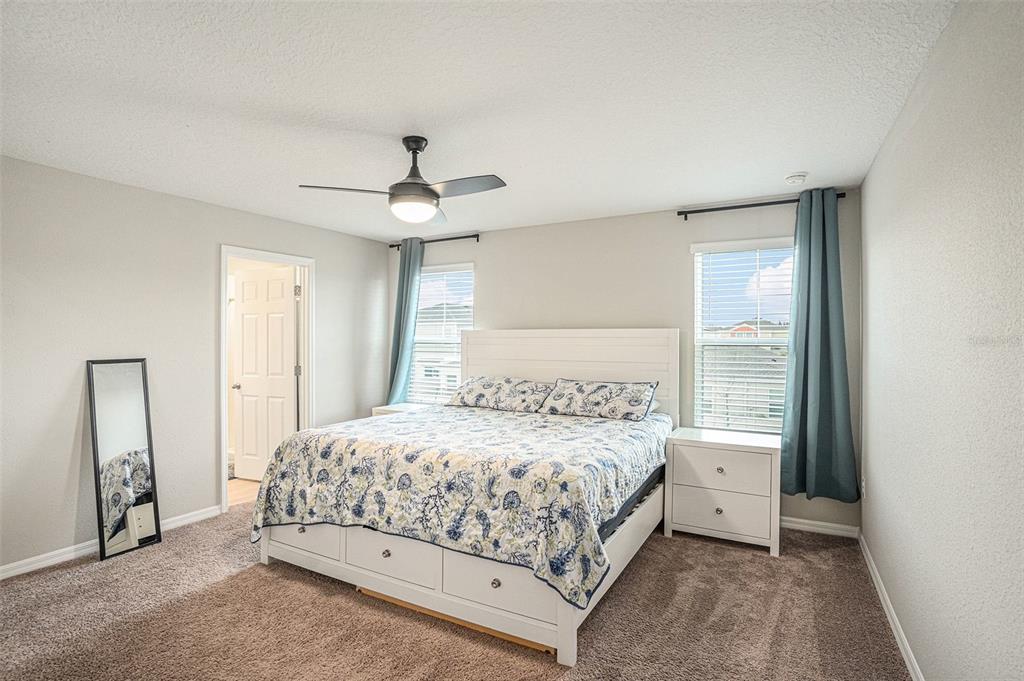 12940 Hawkstone Trail Boulevard Lithia, FL 33547 - Photo 5 of 33 a bedroom with a bed and a chandelier