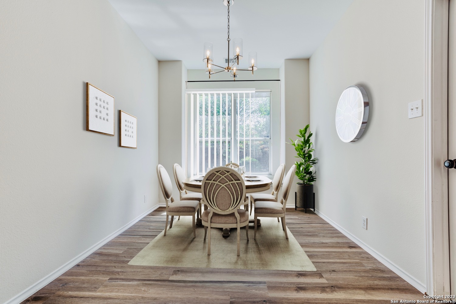a dining room with wooden floor table and chairs