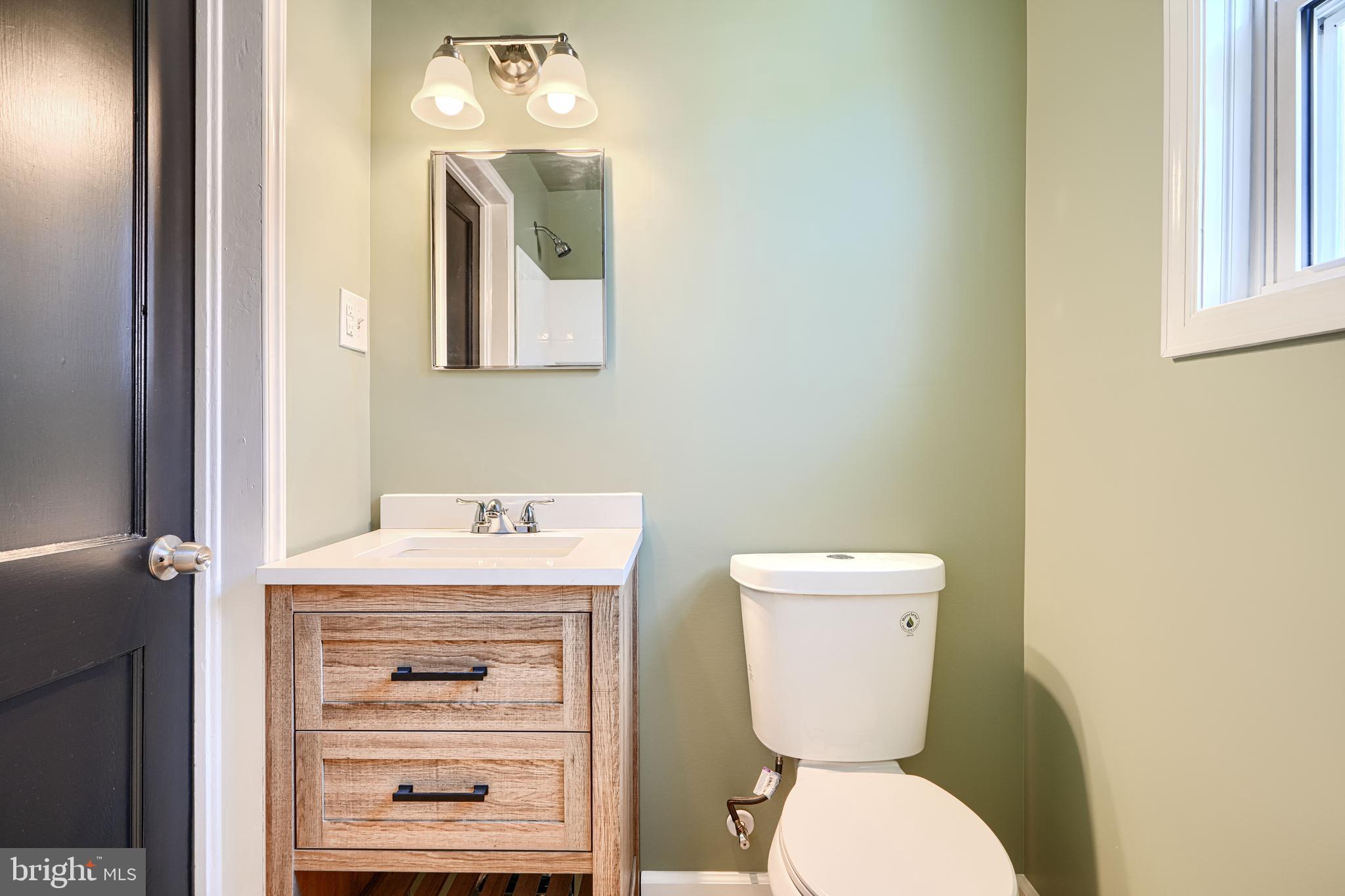 644 48th Street Baltimore, MD 21224 - Photo 28 of 37 a bathroom with a toilet a sink and mirror
