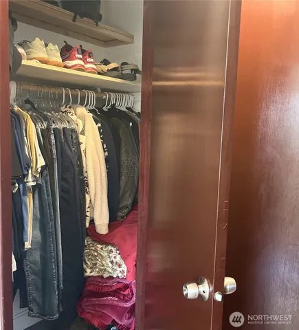 a view of walk in closet with clothes and shoes