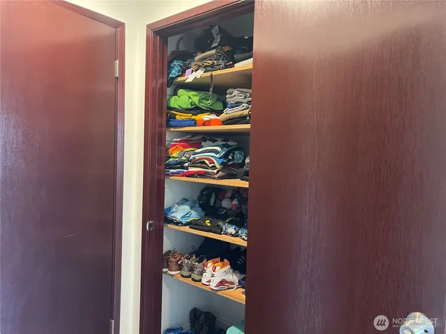 a view of walk in closet with clothes and shoes