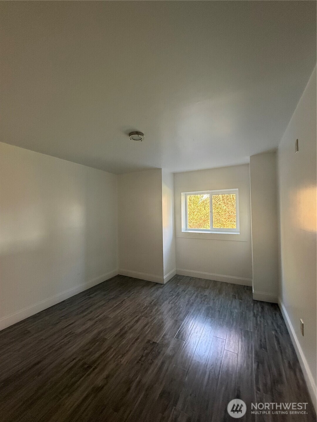 1017 Ballentine Street Raymond, WA 98577 - Photo 24 of 33 an empty room with wooden floor and windows