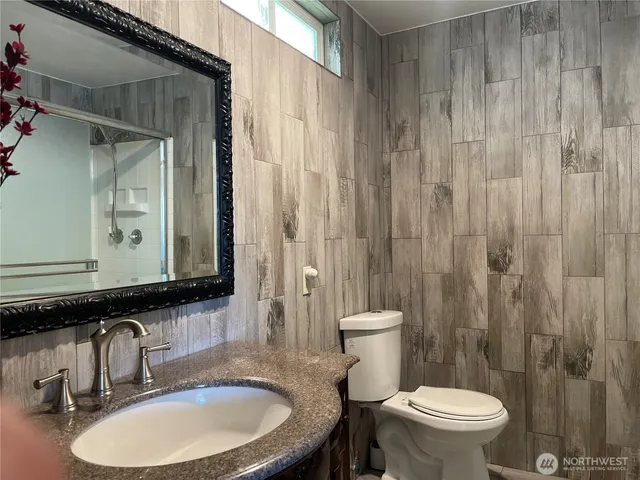 a bathroom with a sink a toilet and mirror