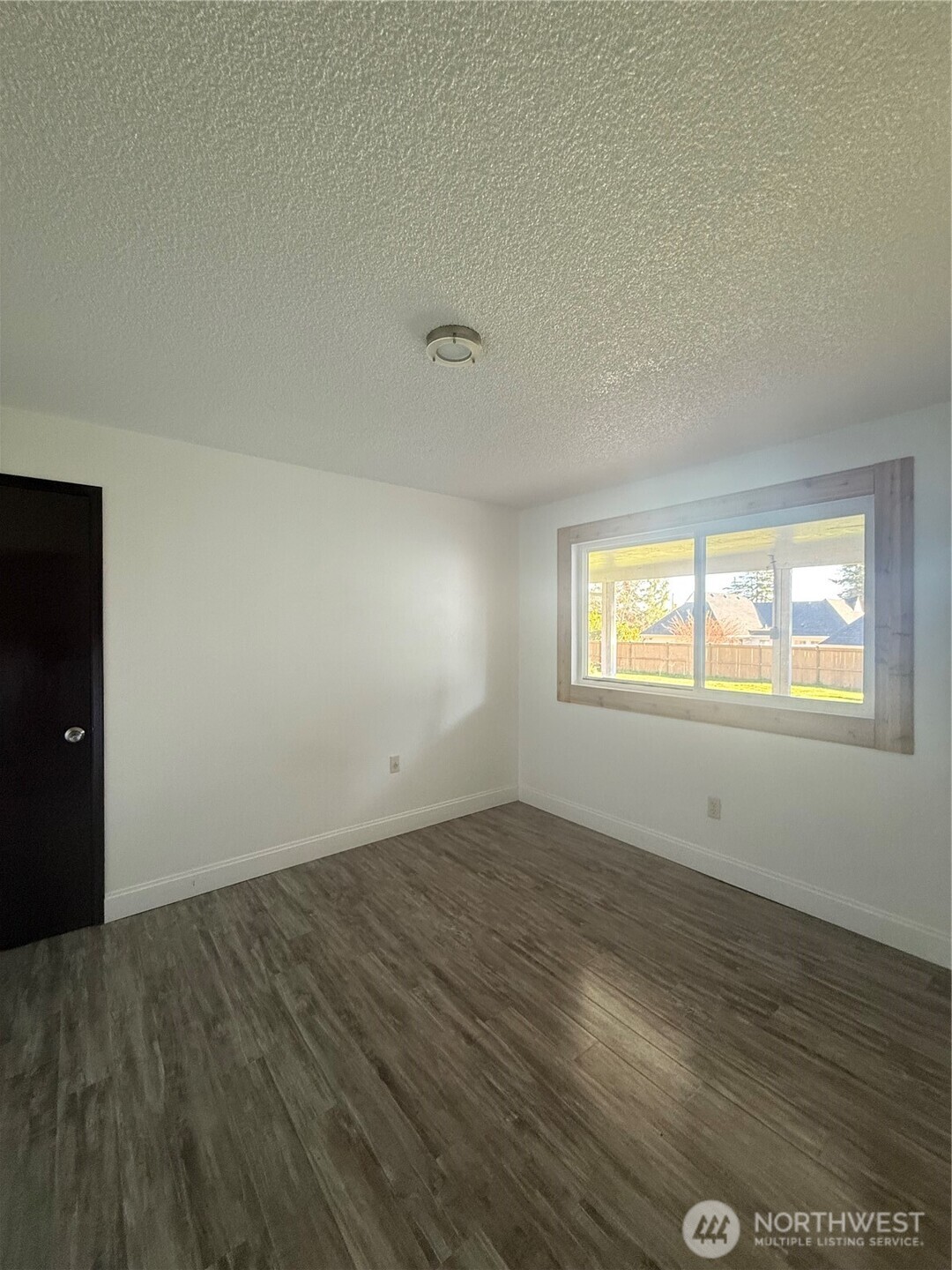 1017 Ballentine Street Raymond, WA 98577 - Photo 28 of 33 an empty room with wooden floor and windows