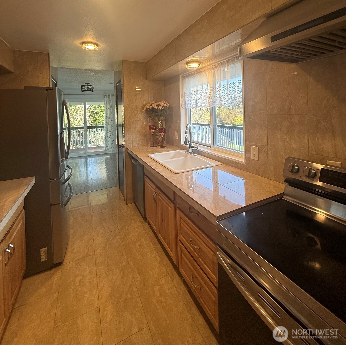 1017 Ballentine Street Raymond, WA 98577 - Photo 9 of 33 a large kitchen with kitchen island a counter space a sink a stove and a refrigerator
