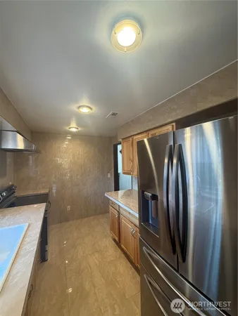 a view of a refrigerator a sink and cabinets