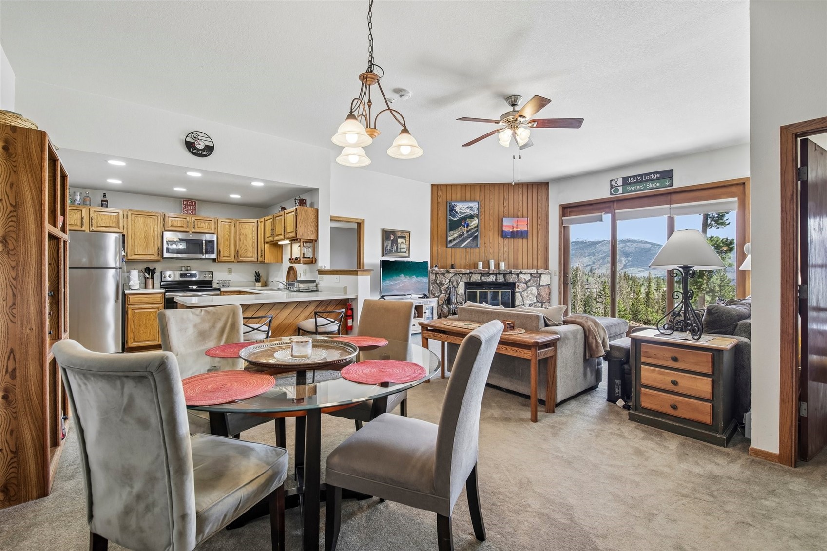 89310 Ryan Gulch Road, Unit 103 Silverthorne, CO 80498 - Photo 4 of 48 a dining room with wooden floor a chandelier a wooden table and chairs