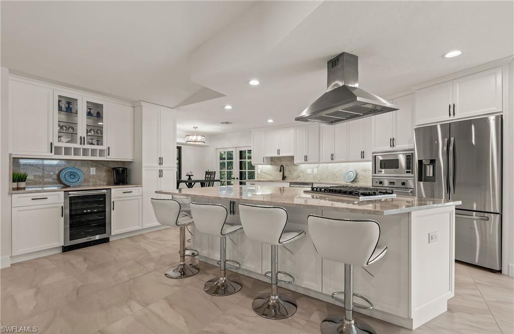2307 Queens Way Naples, FL 34112 - Photo 11 of 41 a kitchen with white cabinets and stainless steel appliances