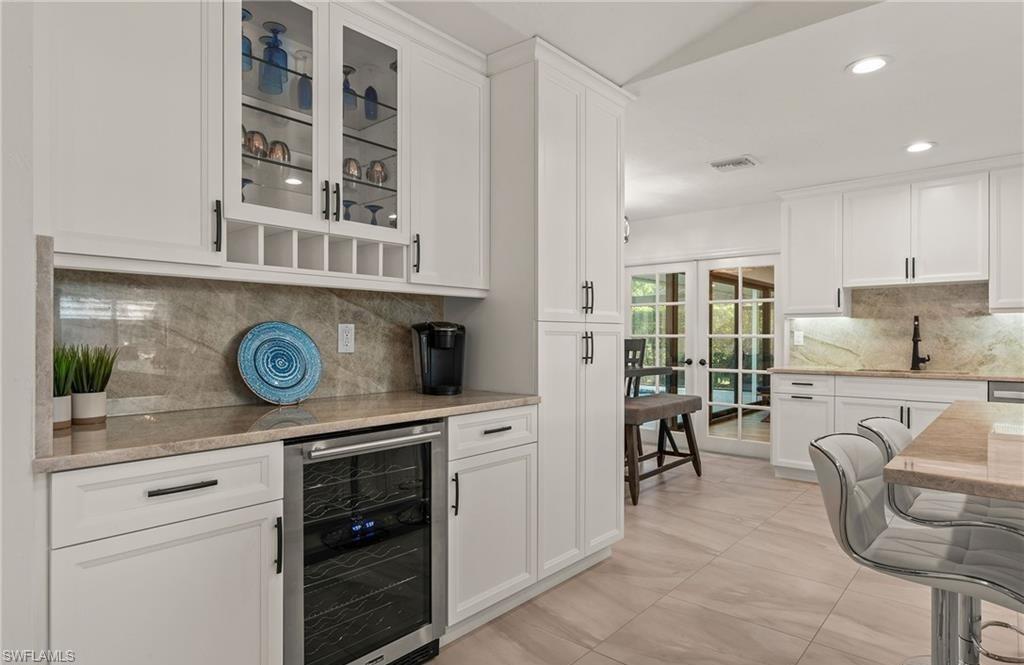 2307 Queens Way Naples, FL 34112 - Photo 12 of 41 a kitchen with stainless steel appliances granite countertop a stove and a sink