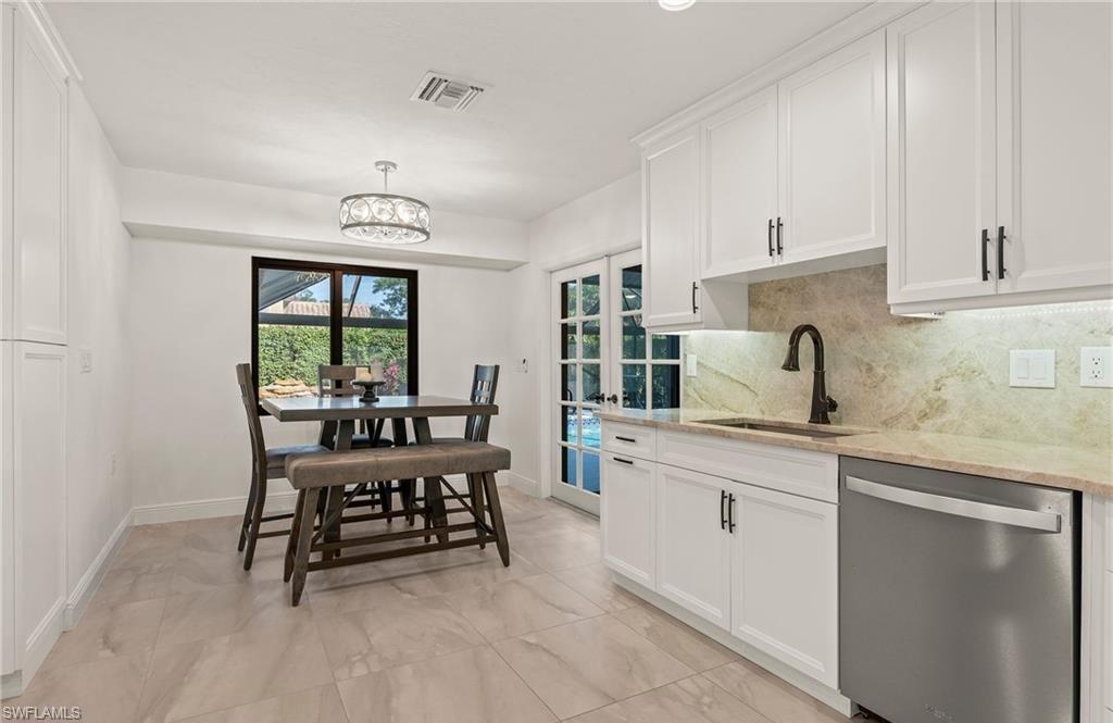 2307 Queens Way Naples, FL 34112 - Photo 15 of 41 a kitchen with a chair and white cabinets