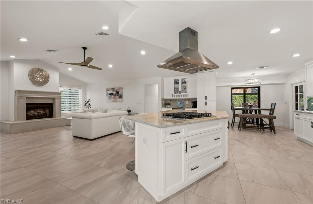 2307 Queens Way Naples, FL 34112 - Photo 8 of 41 a kitchen with stainless steel appliances a stove a sink a dining table and chairs