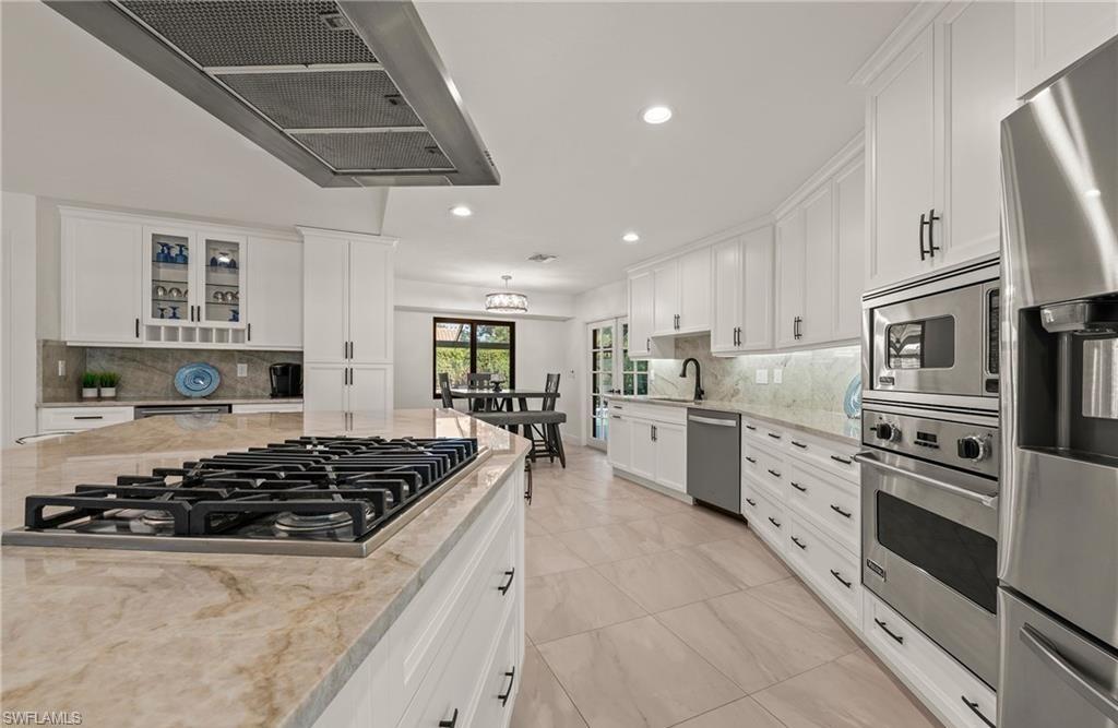 2307 Queens Way Naples, FL 34112 - Photo 10 of 41 a kitchen with stainless steel appliances granite countertop a stove and a sink