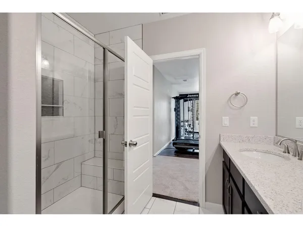 a bathroom with a granite countertop sink a mirror and shower