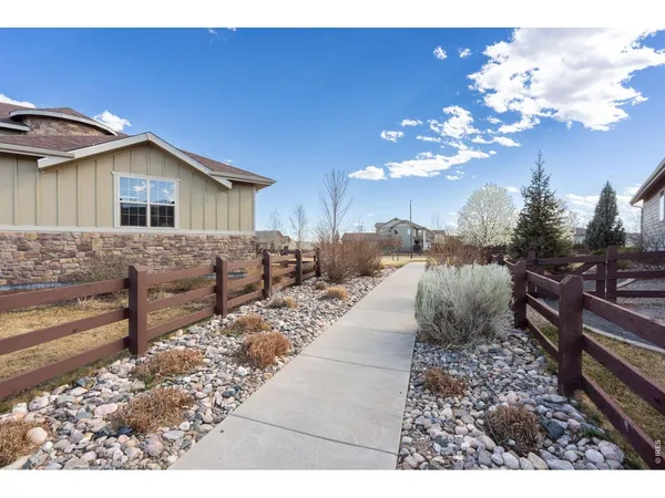 a view of a house with a small yard and wooden fence