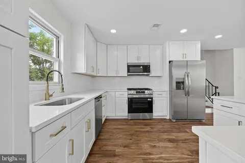 a kitchen with kitchen island granite countertop a sink stove and refrigerator