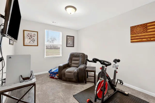 a living room with furniture a flat screen tv and a window