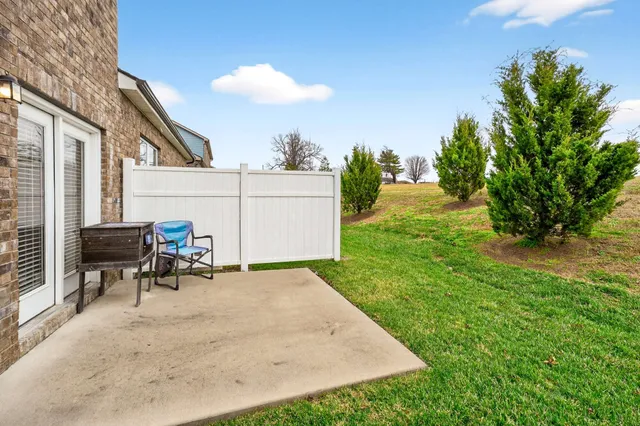 a view of a patio with table and chairs and potted plants with wooden fence