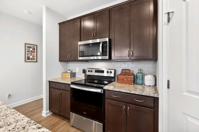a kitchen with granite countertop wooden cabinets and stainless steel appliances