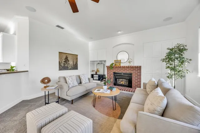 a spacious bedroom with a bed a couch and potted plant