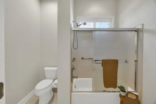 an empty room with window and chandelier fan