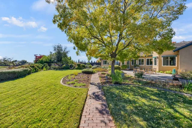 a kitchen with stainless steel appliances a stove a refrigerator a kitchen island with white cabinets and chairs