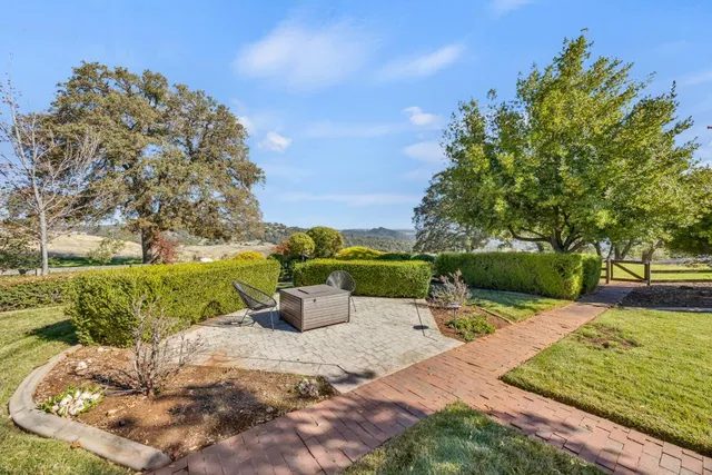 a kitchen with stainless steel appliances granite countertop a stove top oven a sink dishwasher and white cabinets with wooden floor