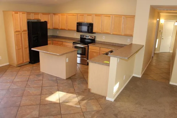 a kitchen with a stove a refrigerator and storage