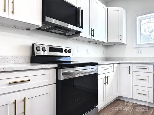 a kitchen with granite countertop cabinets stainless steel appliances and a sink