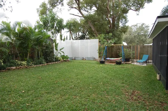 a view of a backyard with a garden and entertaining space