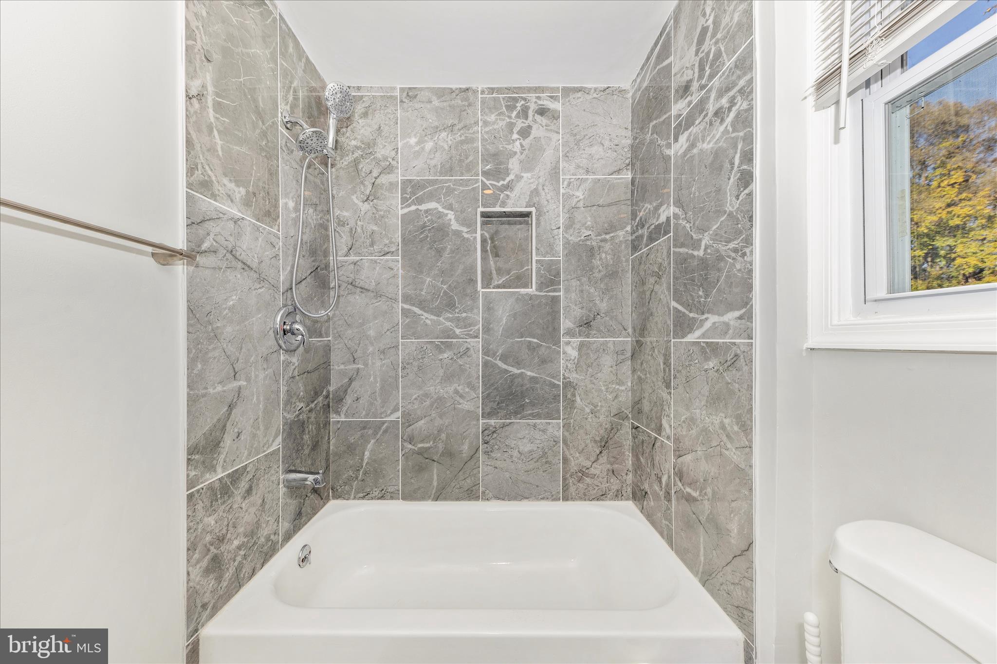 6216 Manor Woods Road Frederick, MD 21703 - Photo 16 of 45 a bath tub sitting next to a white toilet and a shower curtain