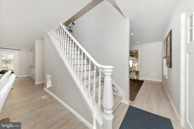 a view of a hallway with wooden floor and staircase