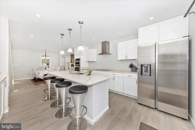 a kitchen with a sink a refrigerator and chairs