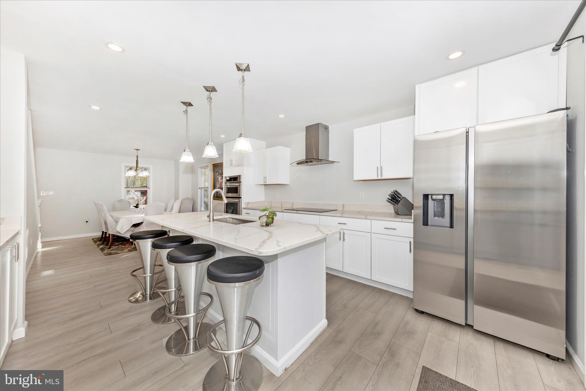 6216 Manor Woods Road Frederick, MD 21703 - Photo 2 of 45 a kitchen with a sink a refrigerator and chairs