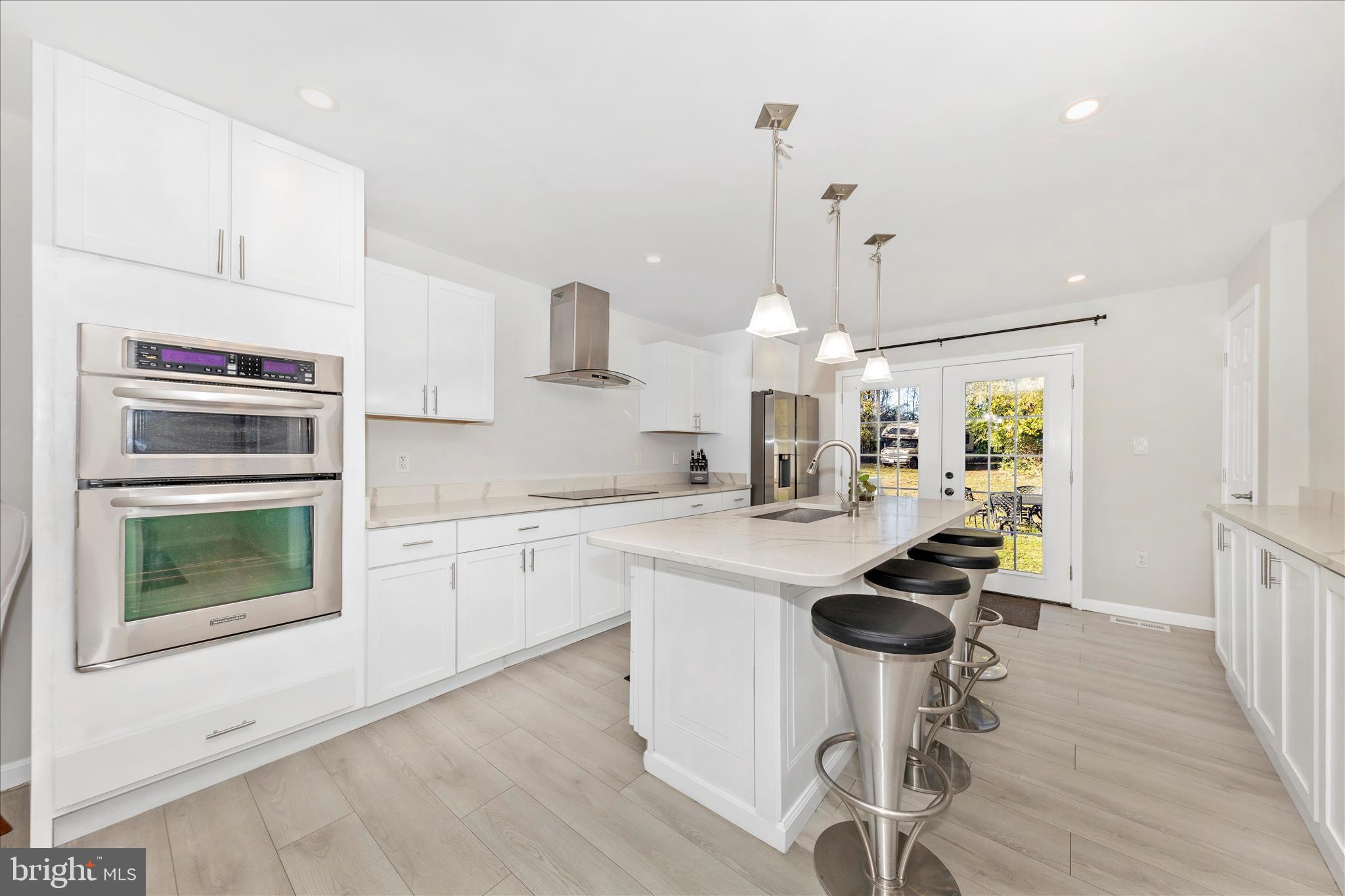 6216 Manor Woods Road Frederick, MD 21703 - Photo 5 of 45 a kitchen with stainless steel appliances a stove a sink cabinets and a wooden floor