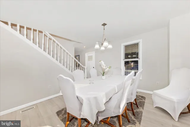 a view of a dining room with furniture a chandelier and wooden floor