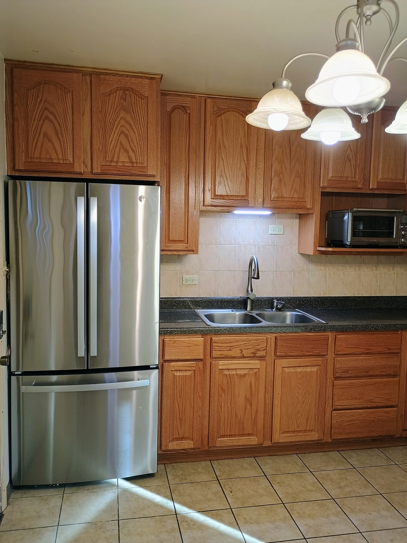 16601 Honore Avenue Markham, IL 60428 - Photo 4 of 11 a kitchen with stainless steel appliances granite countertop a refrigerator a sink a stove and a counter space