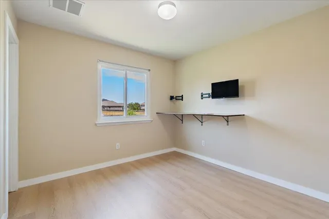 a view of room with window and wooden floor