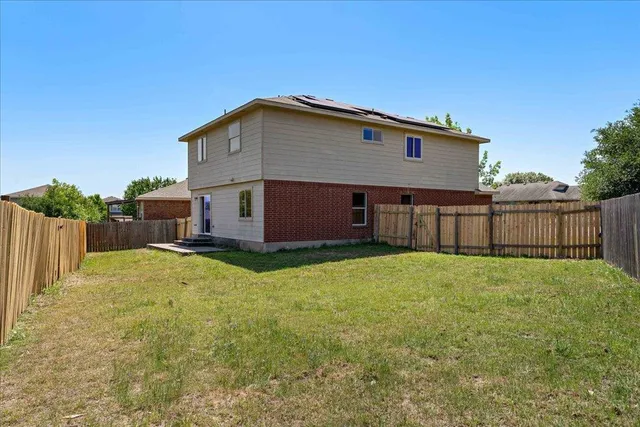a view of a backyard with wooden fence