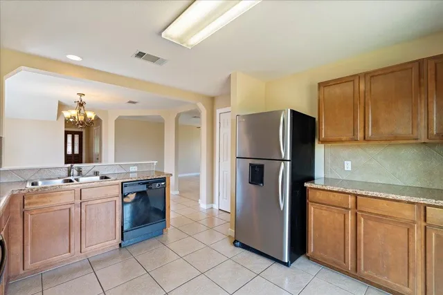 a kitchen with stainless steel appliances granite countertop a refrigerator and a stove top oven