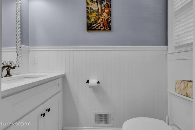 a bathroom with a sink vanity mirror and toilet