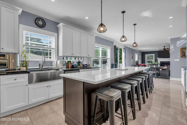a kitchen with stainless steel appliances granite countertop a table chairs sink and cabinets