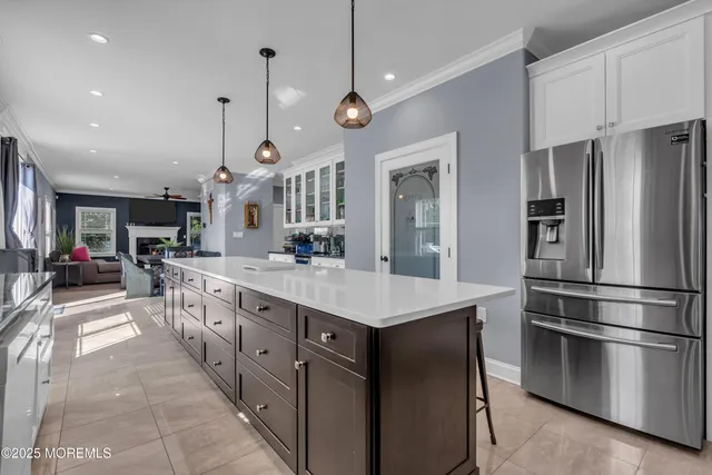 a kitchen with stainless steel appliances kitchen island a refrigerator and a view of living room