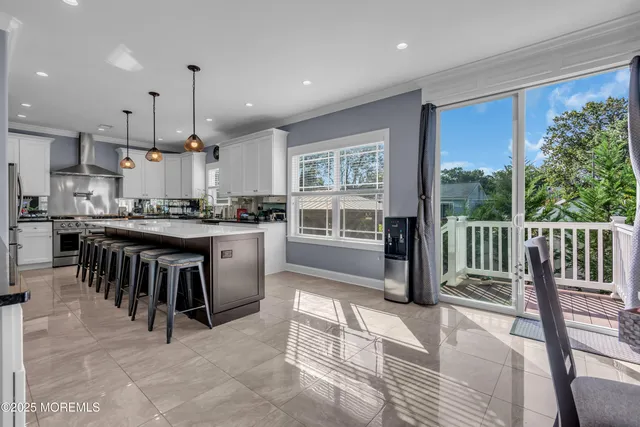 a kitchen with kitchen island a stove a sink a oven with a dining table and chairs