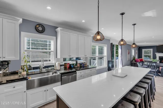 a kitchen with stainless steel appliances granite countertop a stove a sink a refrigerator a dining table and chairs